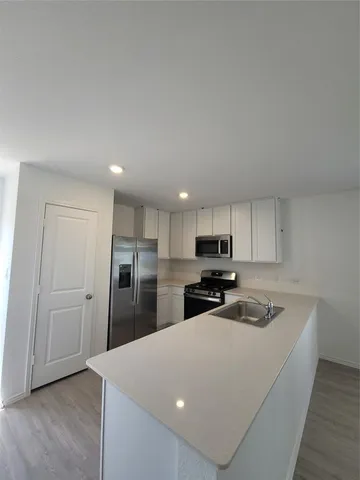 a kitchen with stainless steel appliances a refrigerator sink and microwave