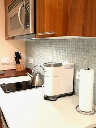 a kitchen with a sink and a stove with wooden floor
