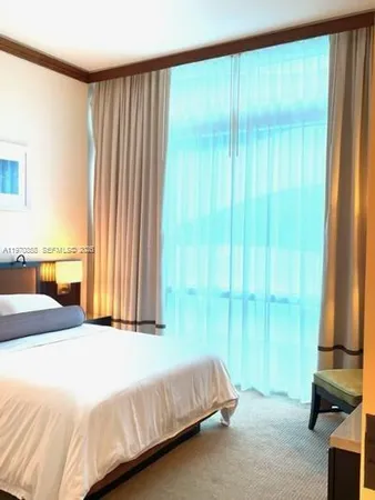 a bedroom with a bed and large window