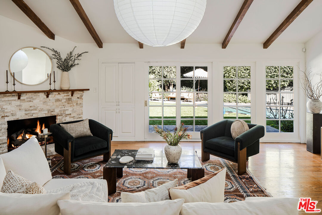 10225 Valley Spring Lane Toluca Lake, CA 91602 - Photo 1 of 2 a living room with furniture a fireplace and a large window
