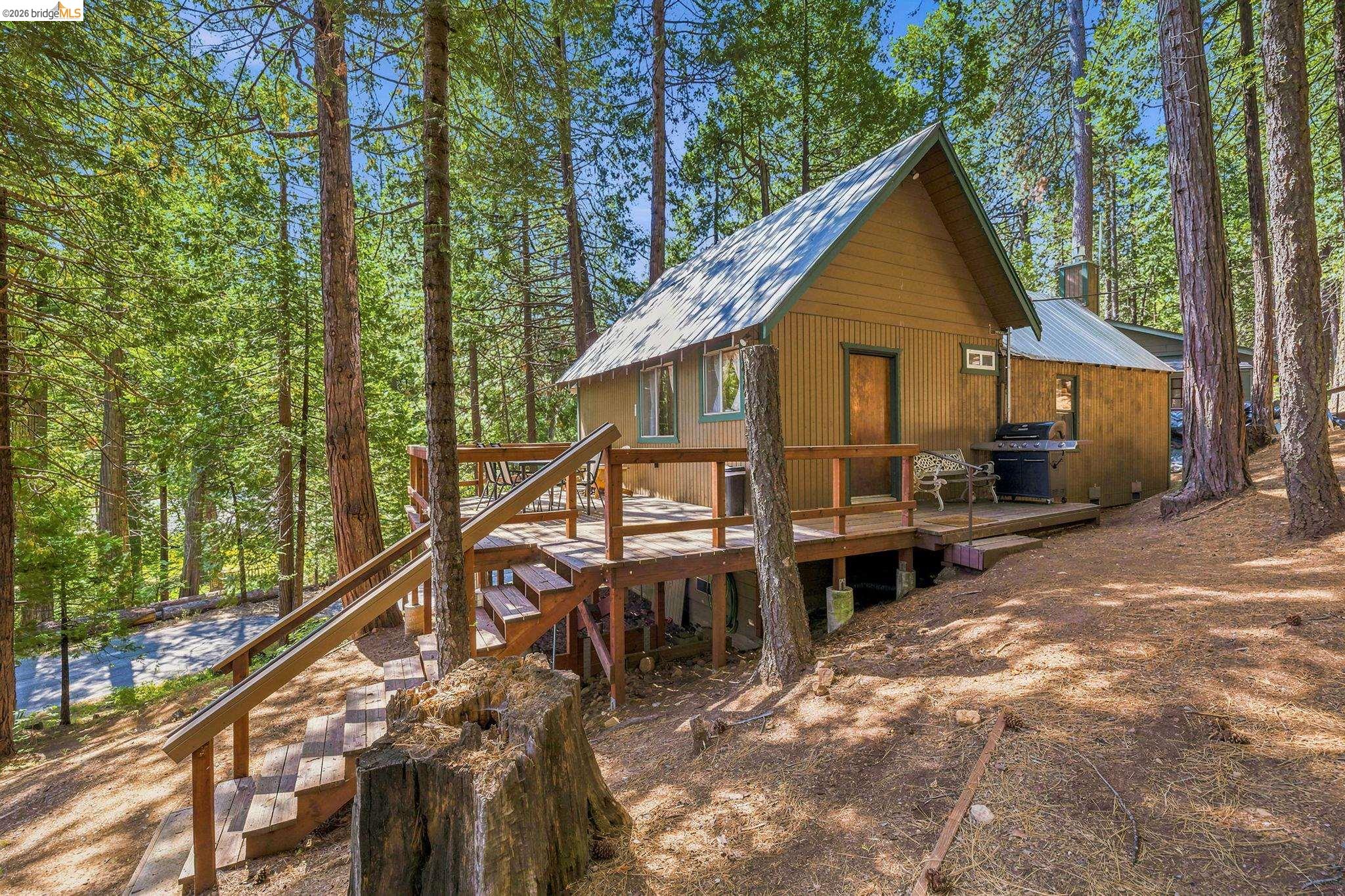 26457 Crystal Road Long Barn, CA 95335 - Photo 8 of 39 A-frame style residence featuring a prominent front deck with stairway access, a metal roof, and vertical siding