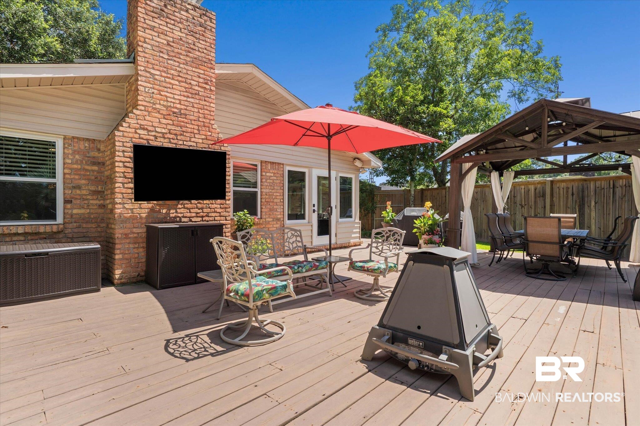 101 Ann Street Daphne, AL 36527 - Photo 26 of 38 Spacious wood-finish deck featuring a brick-clad exterior wall, a large entertainment screen, and a dedicated covered gazebo