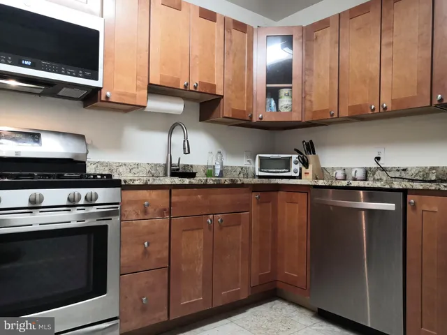 a kitchen with stainless steel appliances granite countertop a stove and a microwave