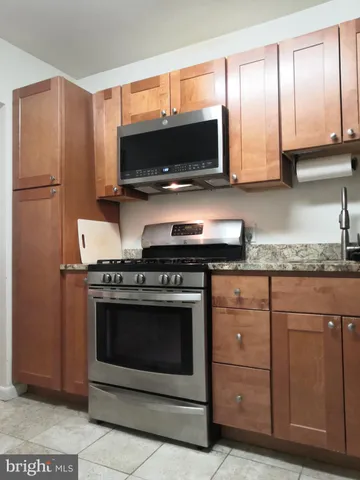 a kitchen with stainless steel appliances granite countertop a stove microwave and refrigerator