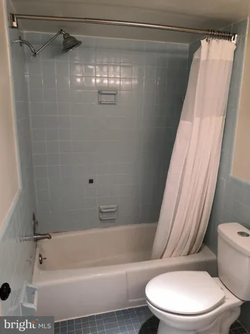 a white toilet sitting next to a bath tub