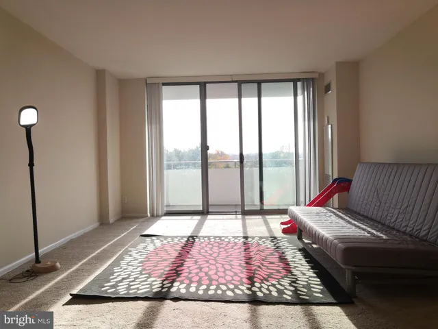 a living room with a bed and a rug