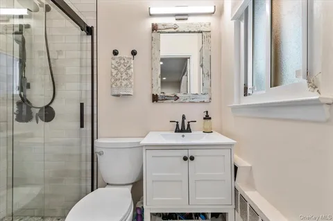 a bathroom with a toilet sink vanity and mirror
