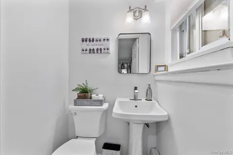 a bathroom with a sink mirror and toilet