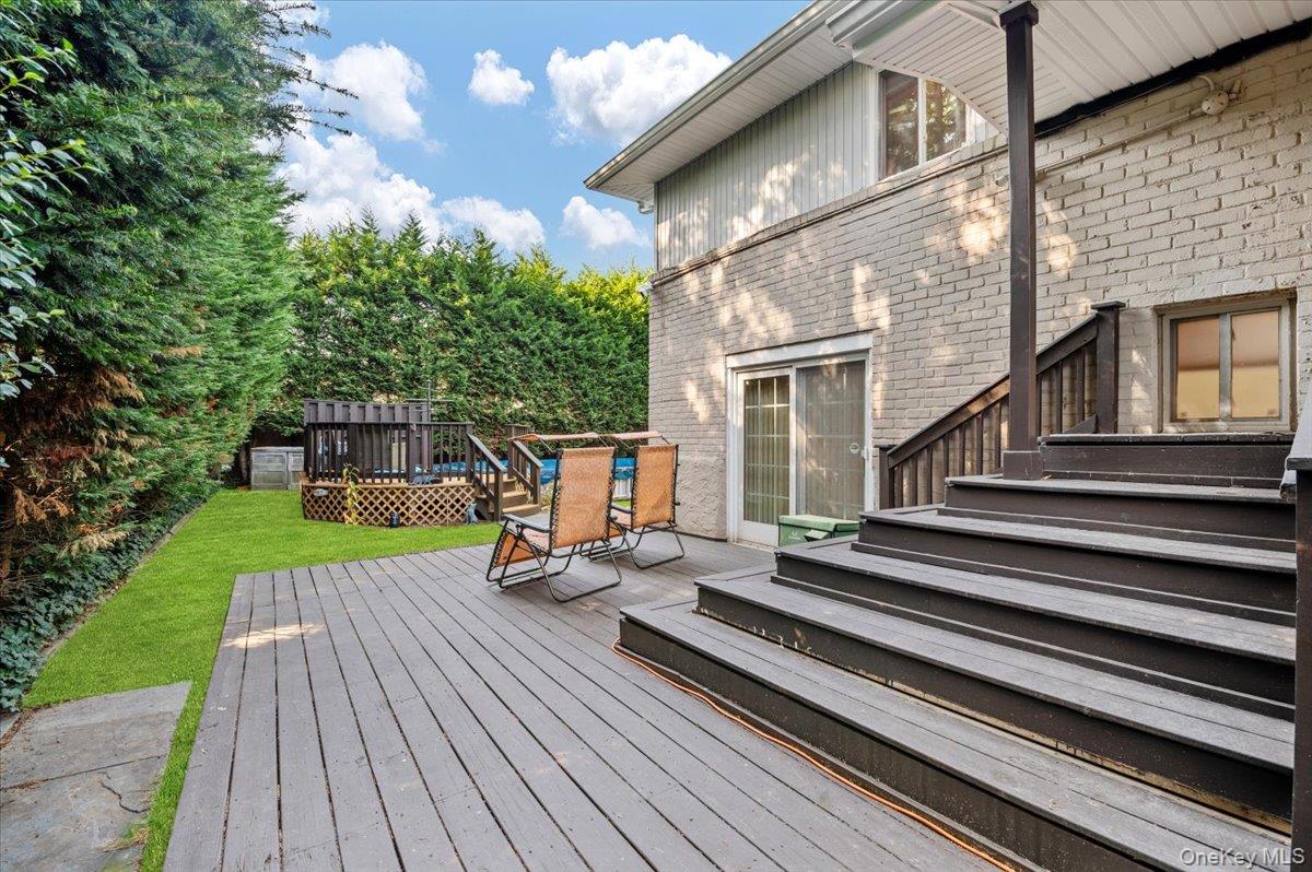 2 Doone Drive Syosset, NY 11791 - Photo 22 of 23 a view of a house with backyard sitting area and wooden deck