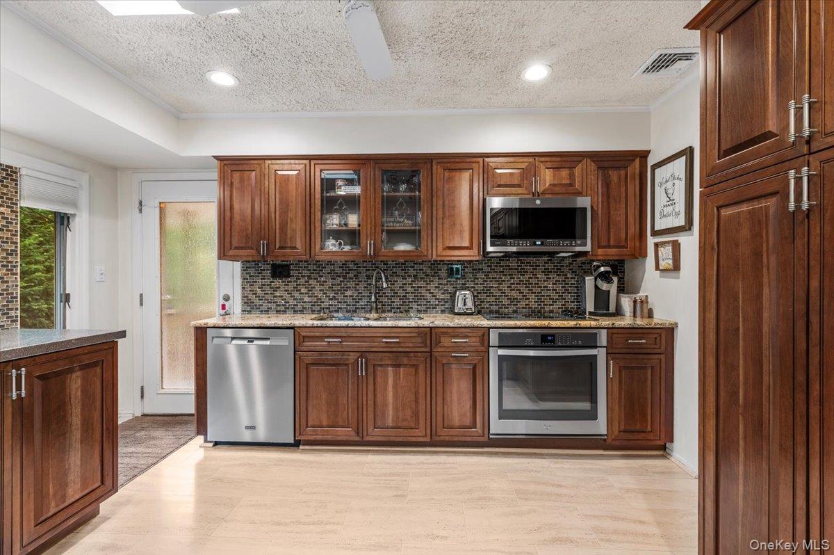 2 Doone Drive Syosset, NY 11791 - Photo 9 of 23 a kitchen with stainless steel appliances granite countertop a stove a sink and a microwave