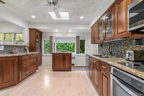 a kitchen with stainless steel appliances granite countertop a sink stove and cabinets