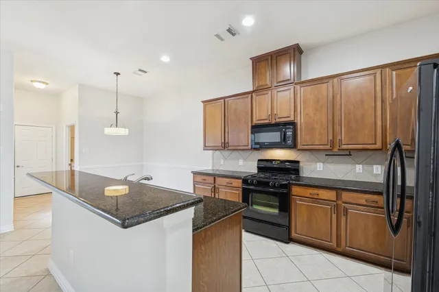 a kitchen with granite countertop a sink stainless steel appliances and cabinets