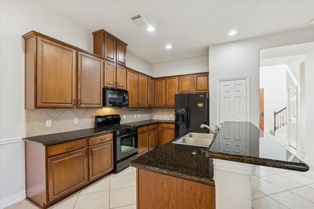 a kitchen with granite countertop a sink stainless steel appliances and cabinets