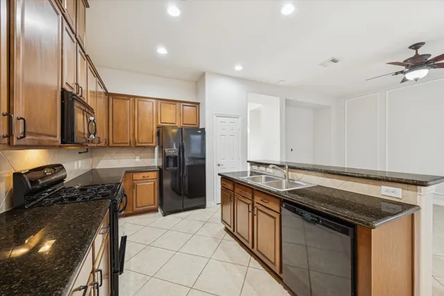 a kitchen with stainless steel appliances granite countertop a stove a sink and a refrigerator