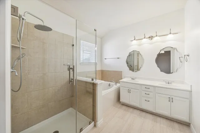 a bathroom with a double vanity sink mirror and shower