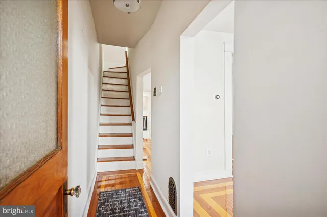 a view of a hallway with wooden floor and entryway
