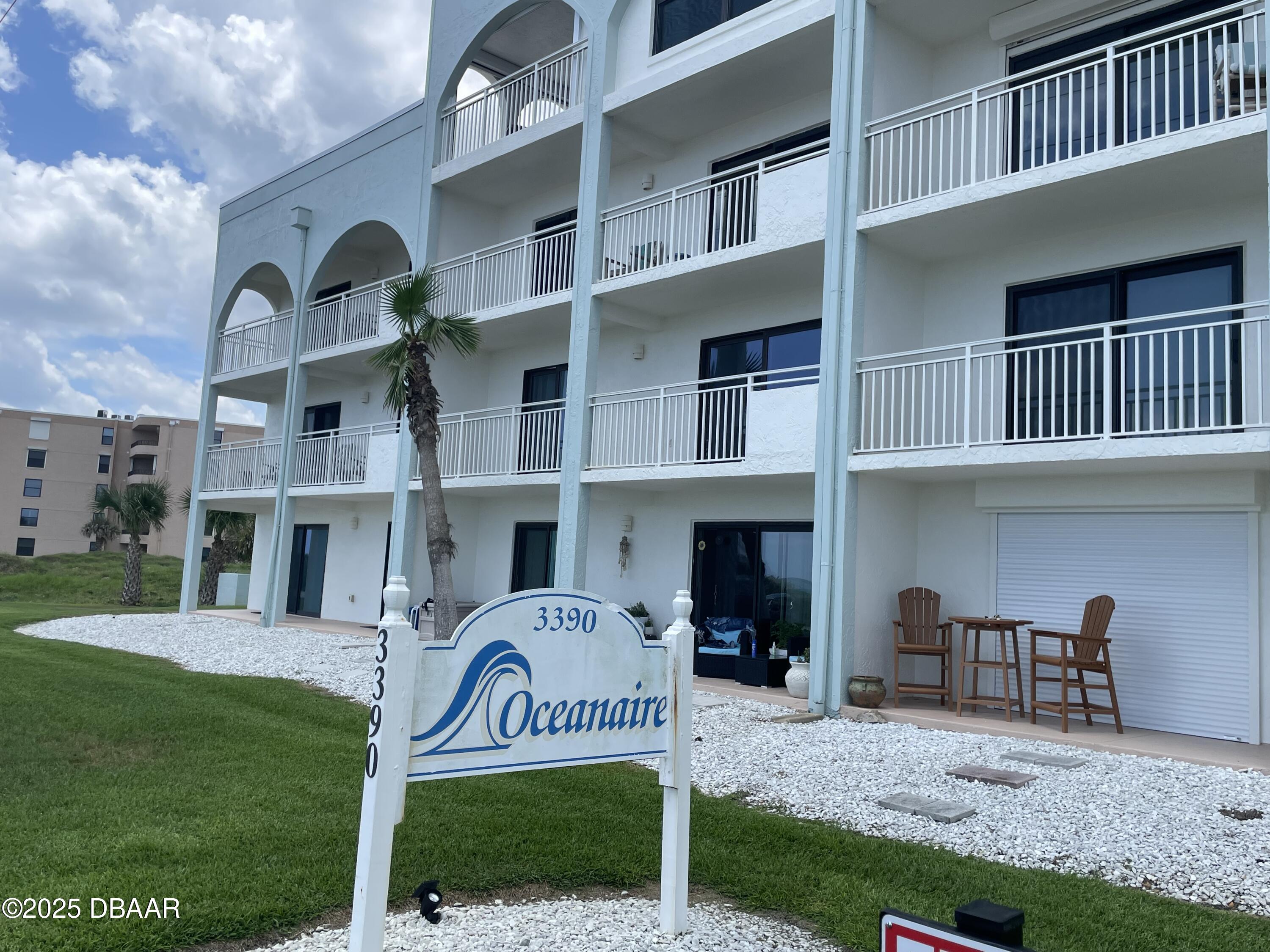 3390 Ocean Shore Boulevard, Unit 101 Ormond Beach, FL 32176 - Photo 1 of 33 a front view of a house with a yard
