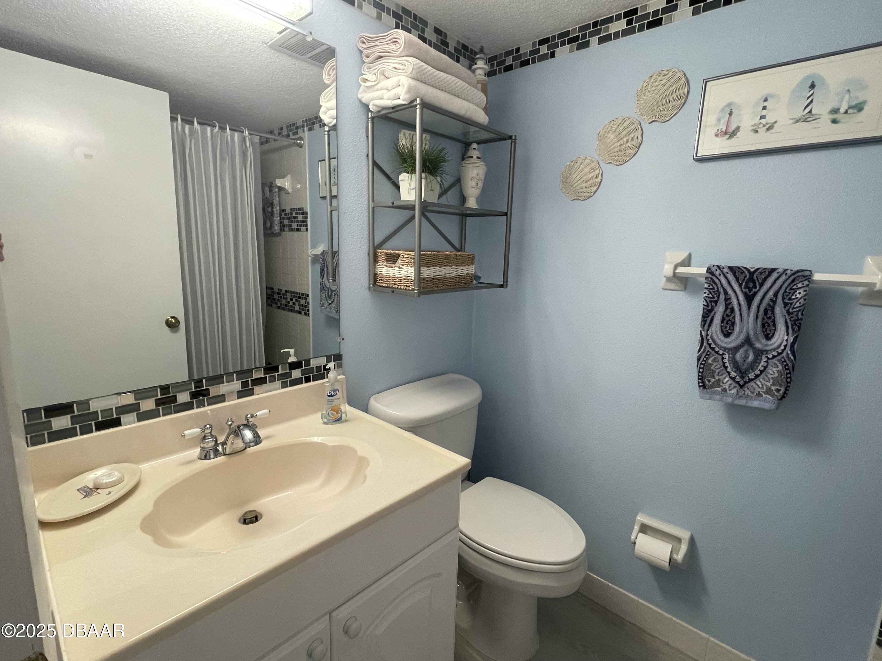 3390 Ocean Shore Boulevard, Unit 101 Ormond Beach, FL 32176 - Photo 18 of 33 a bathroom with a sink mirror and toilet