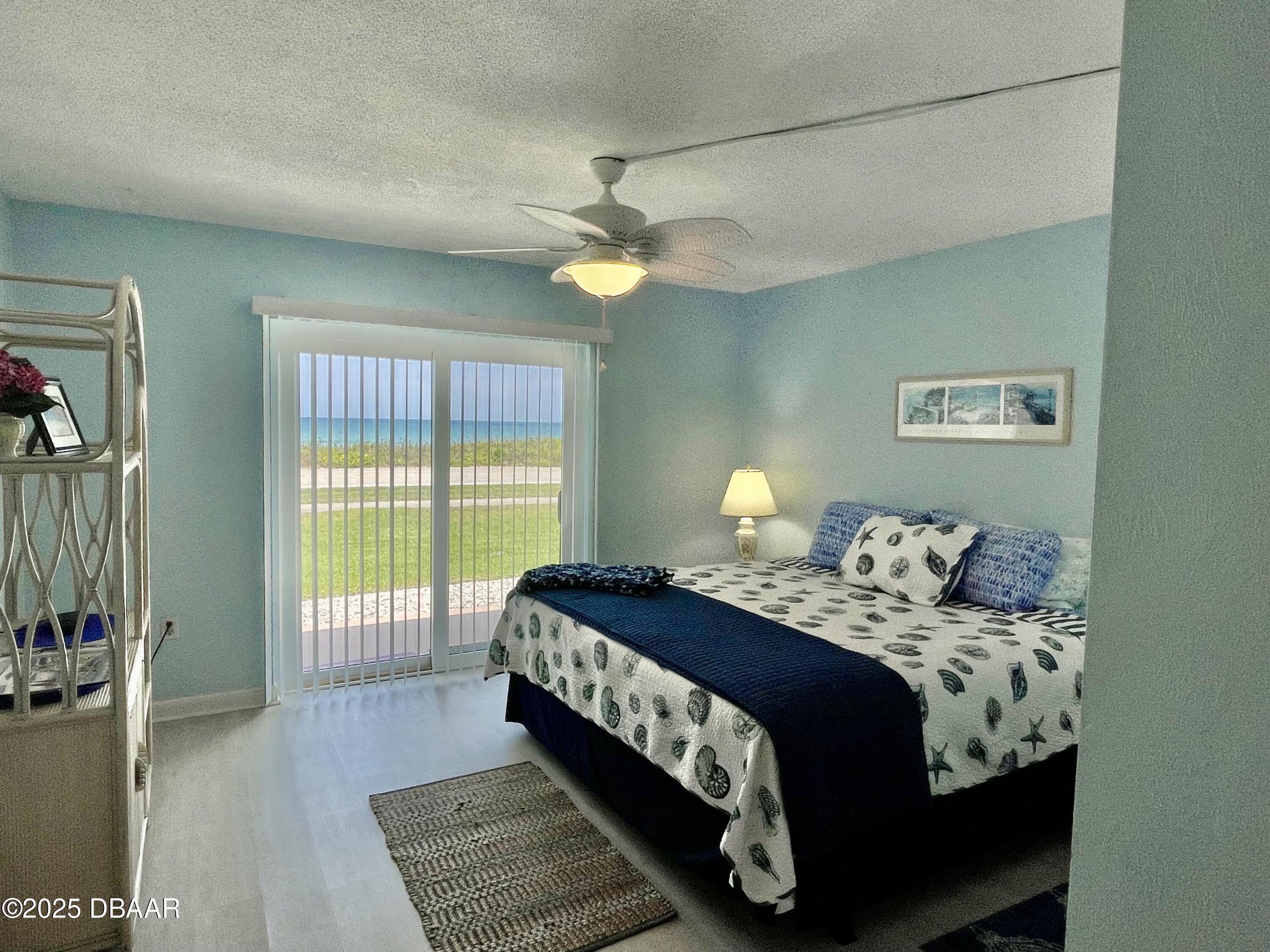 3390 Ocean Shore Boulevard, Unit 101 Ormond Beach, FL 32176 - Photo 22 of 33 a bedroom with a bed and a chandelier