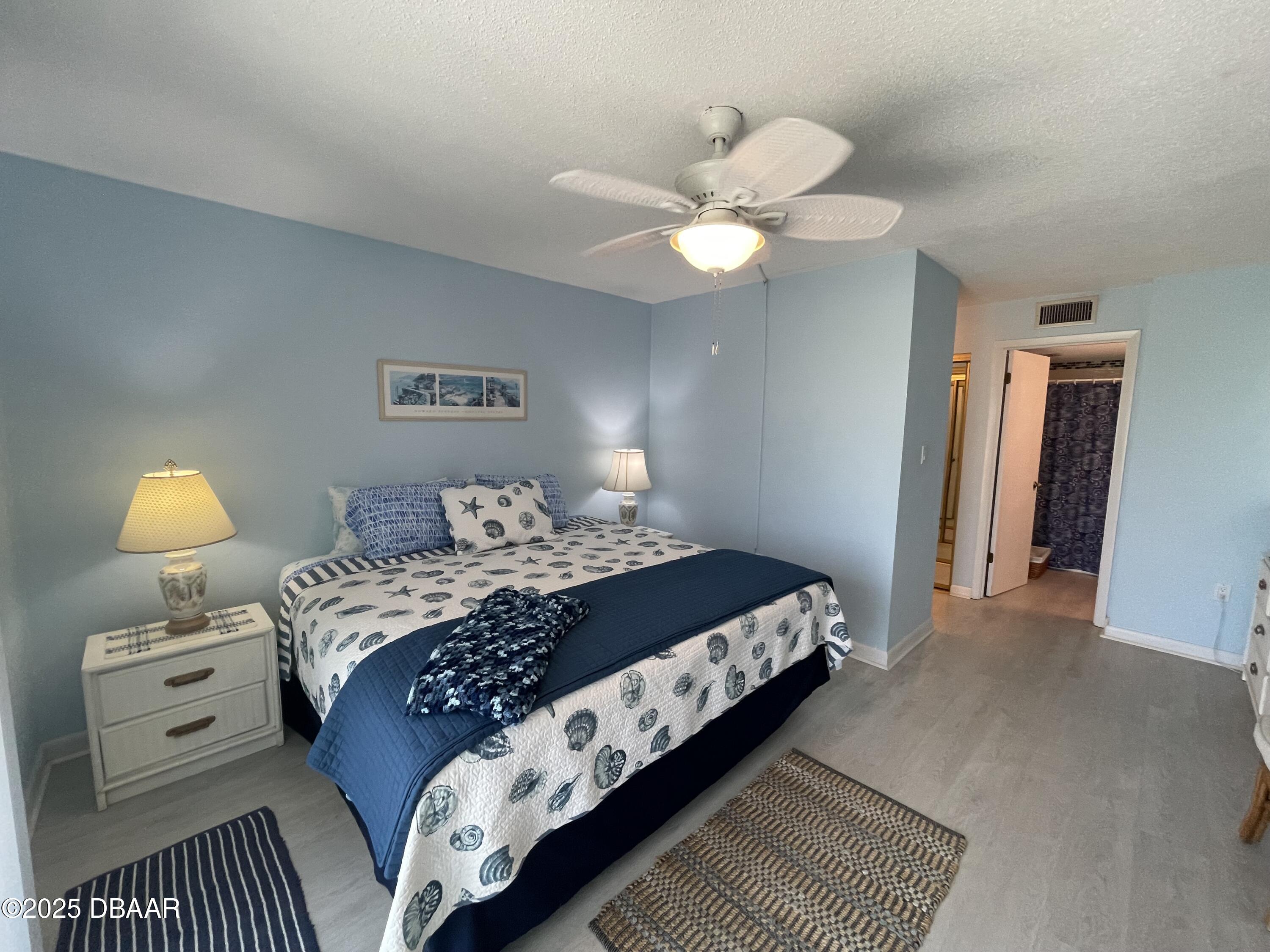 3390 Ocean Shore Boulevard, Unit 101 Ormond Beach, FL 32176 - Photo 23 of 33 a bedroom with a bed and a lamp