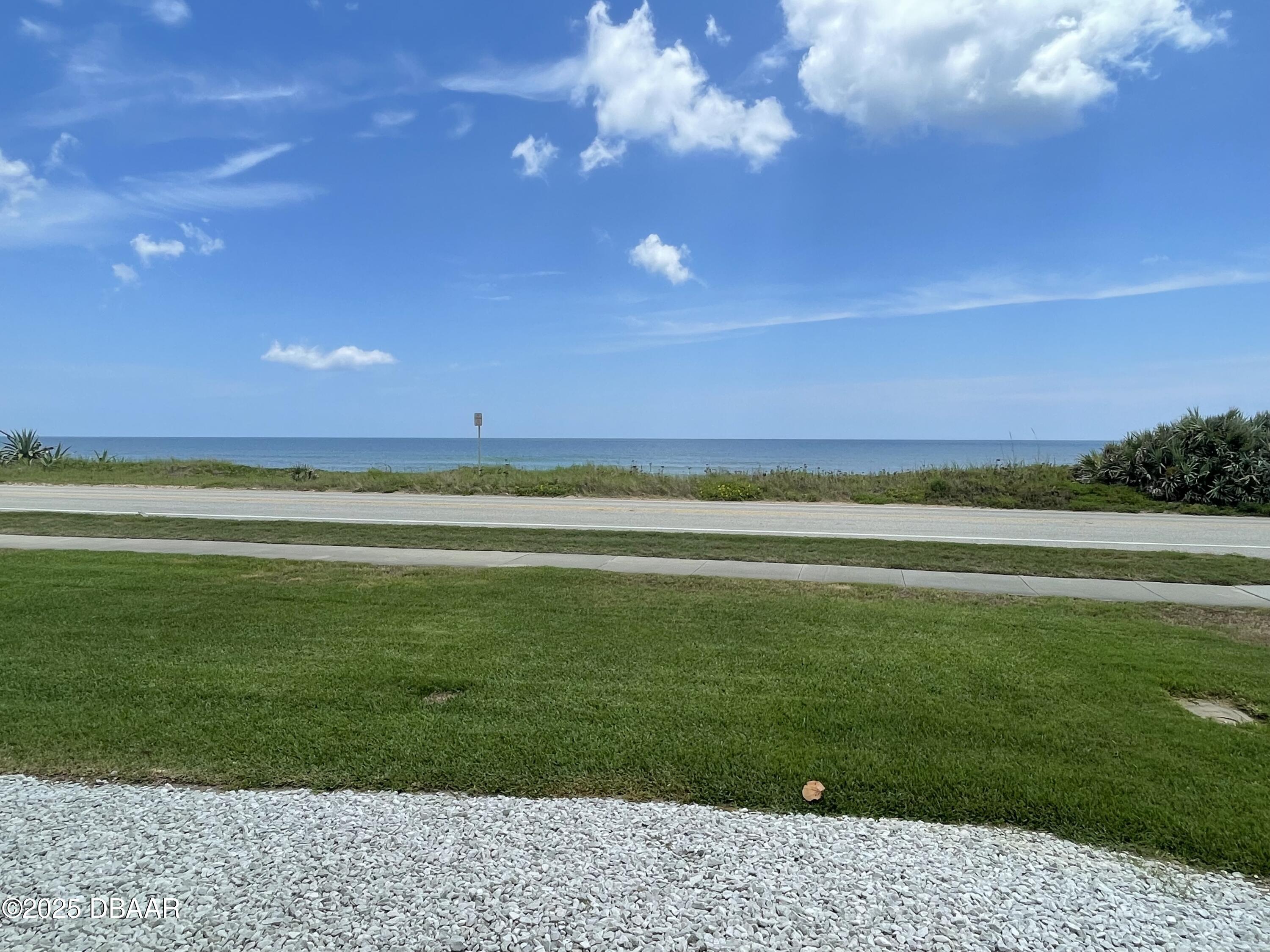 3390 Ocean Shore Boulevard, Unit 101 Ormond Beach, FL 32176 - Photo 27 of 33 a view of an ocean and a yard