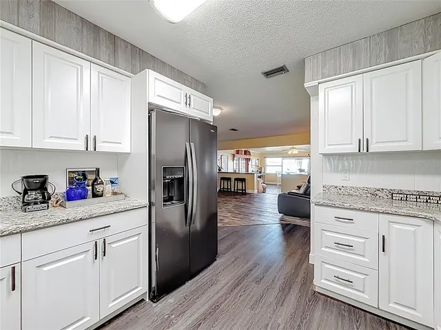 a living room with furniture a chandelier and a dining table with wooden floor