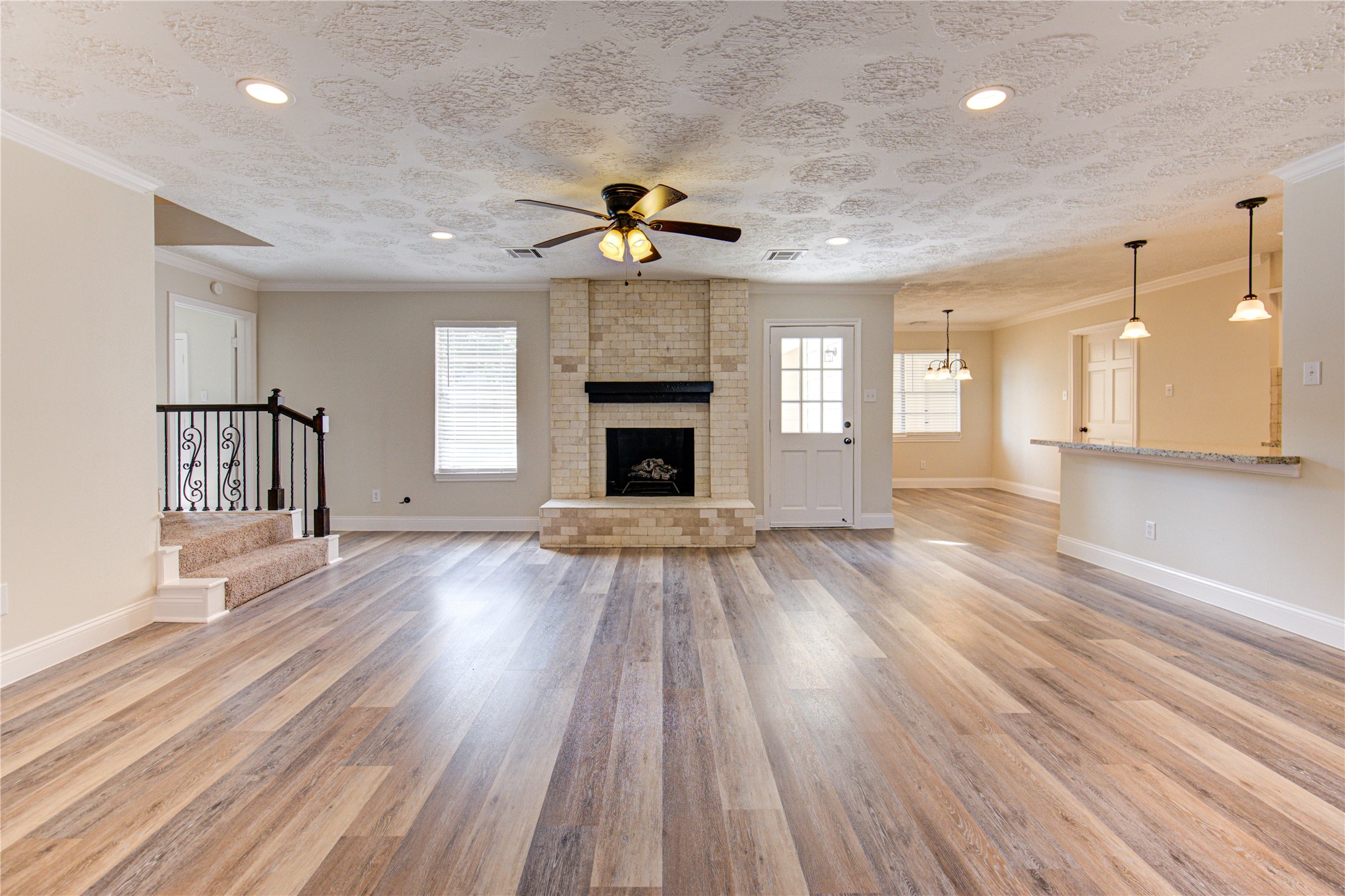 9115 Taidswood Drive Spring, TX 77379 - Photo 11 of 41 Here, you can see this large family room opened to the breakfast area and kitchen. The fireplace is surrounded with travertine, a nice mantel, and hearth. note the beautiful new floors and the recessed LED lighting.