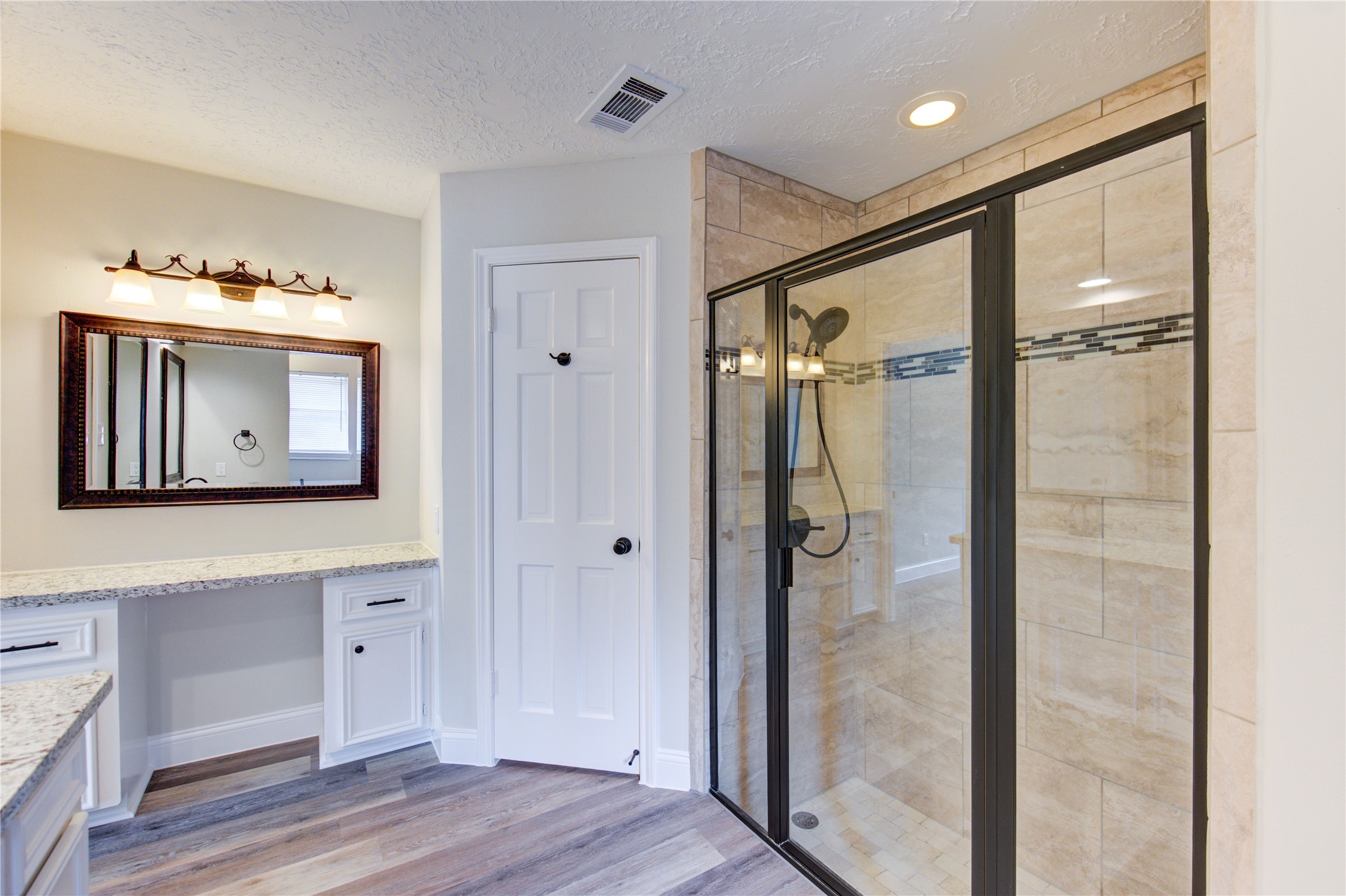 9115 Taidswood Drive Spring, TX 77379 - Photo 24 of 41 The primary bath has double sinks and a separate vanity area. The shower has decorative mosaic inserts, and a glass shower door.