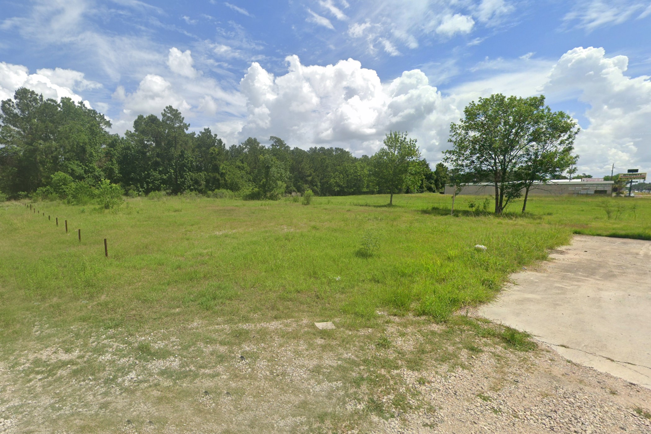4855 Atascocita Road Humble, TX 77346 - Photo 5 of 6 Spacious, open plot of land with lush greenery, ideal for development. It features a mix of grass and mature trees, offering a serene setting. The area has a rural feel with easy access to nearby amenities.