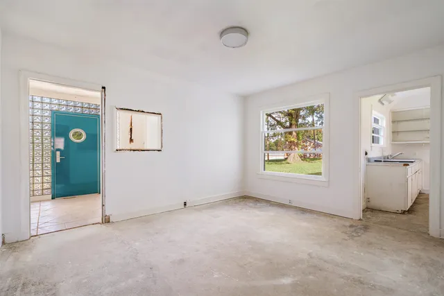 an empty room with a fireplace and a window