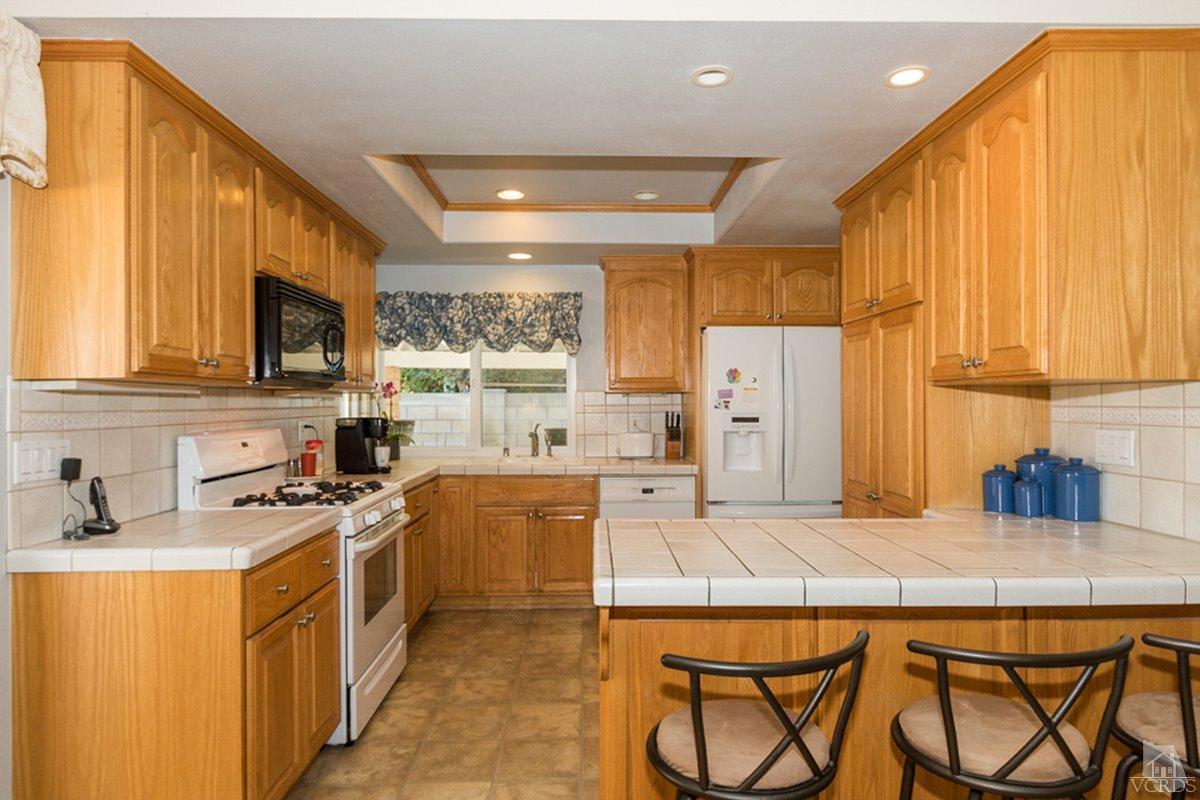 938 Erringer Road Simi Valley, CA 93065 - Photo 14 of 28 a kitchen with stainless steel appliances a stove a sink dishwasher and a refrigerator