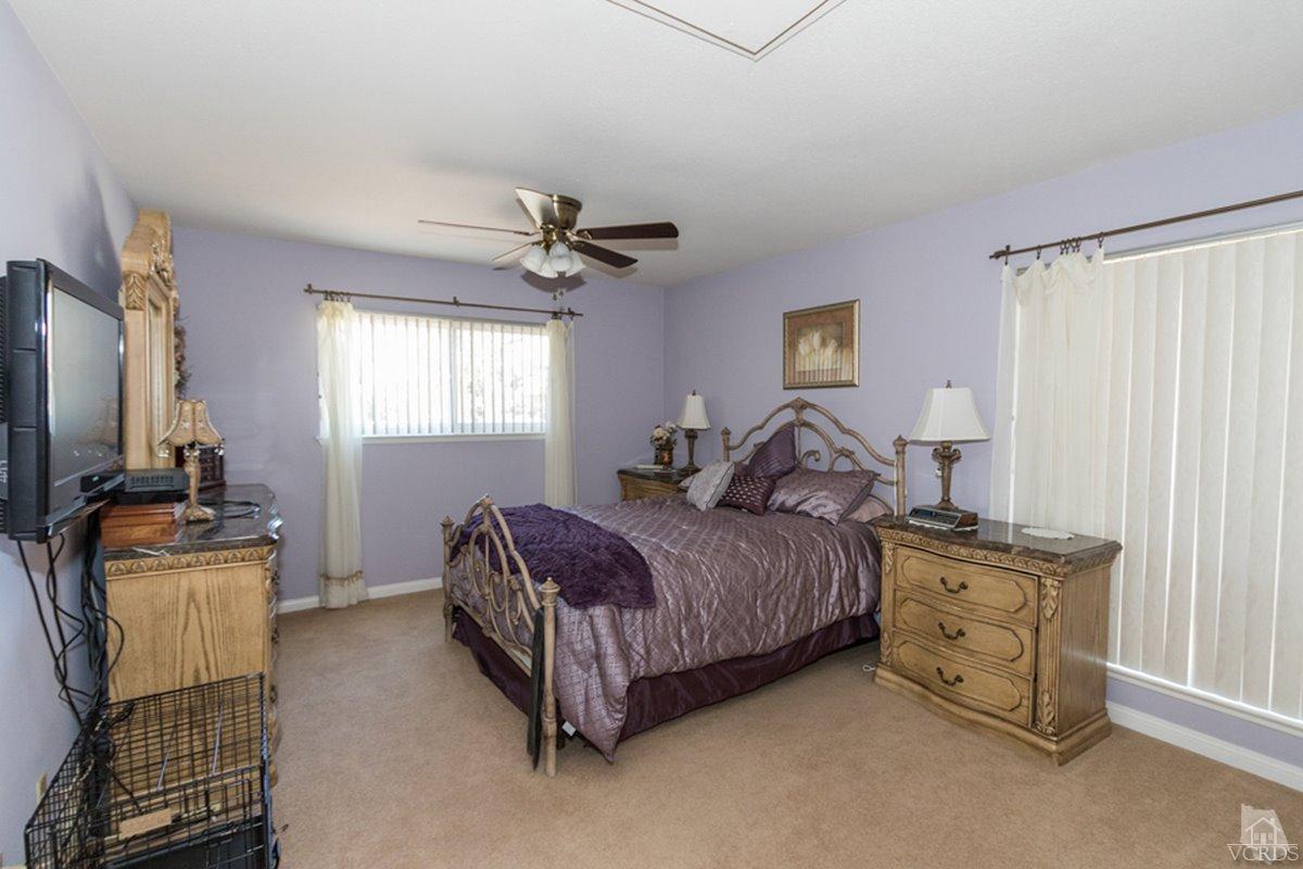 938 Erringer Road Simi Valley, CA 93065 - Photo 23 of 28 a spacious bedroom with a bed and a chandelier