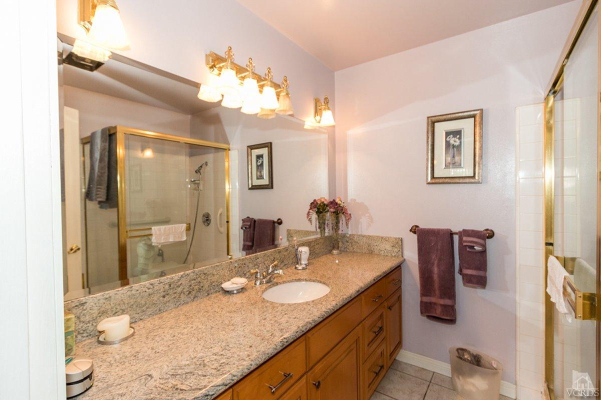 938 Erringer Road Simi Valley, CA 93065 - Photo 24 of 28 a bathroom with a granite countertop sink a mirror and shower