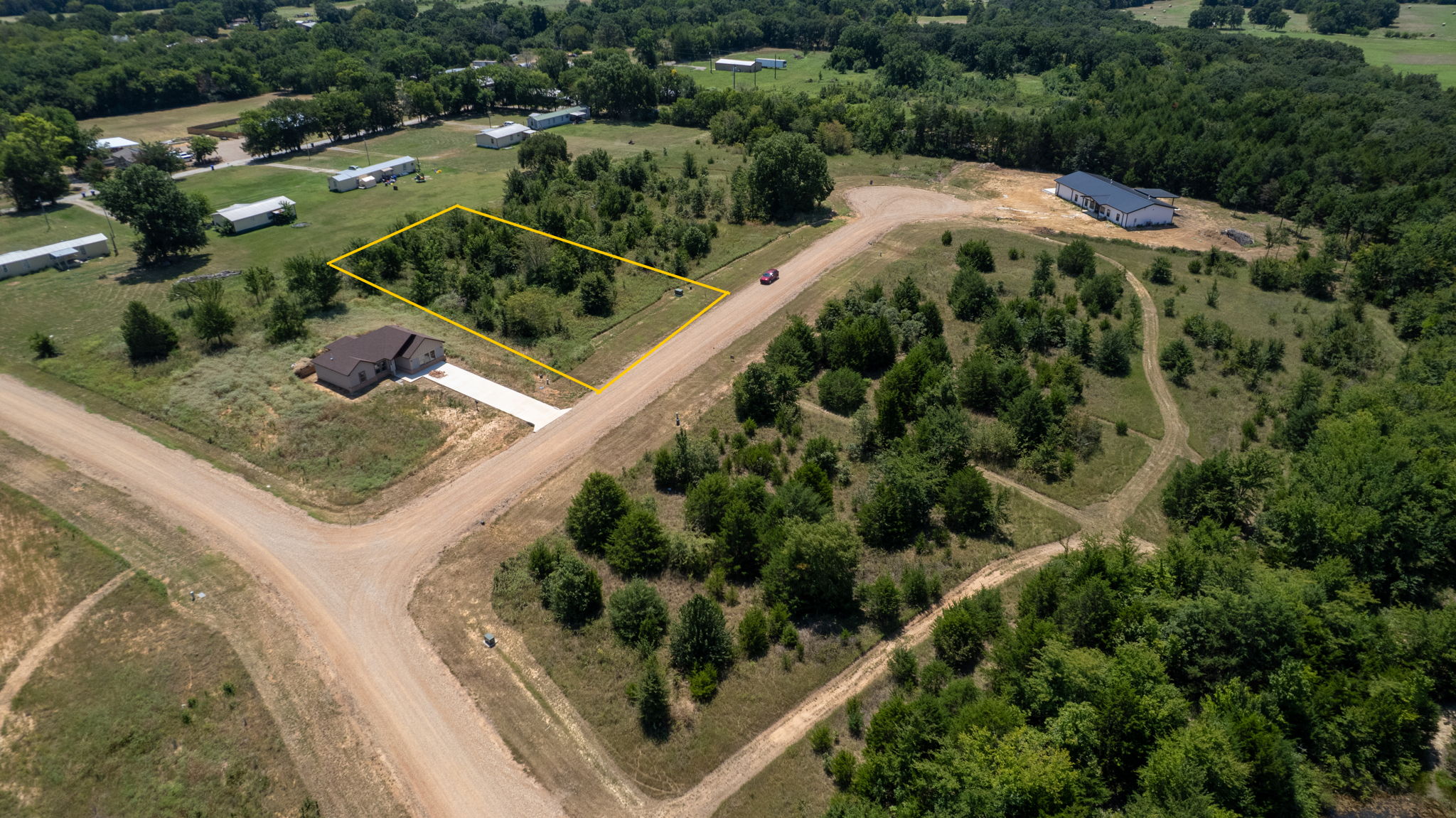 0 Redbird Lane Colbert, OK 74733 - Photo 6 of 6 Expansive rural property featuring multiple parcels with mature tree-lined landscaping, established gravel driveways, and a mix of cleared and wooded acreage
