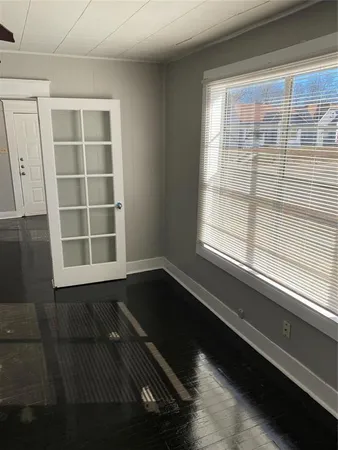 a view of an empty room with a window and wooden floor