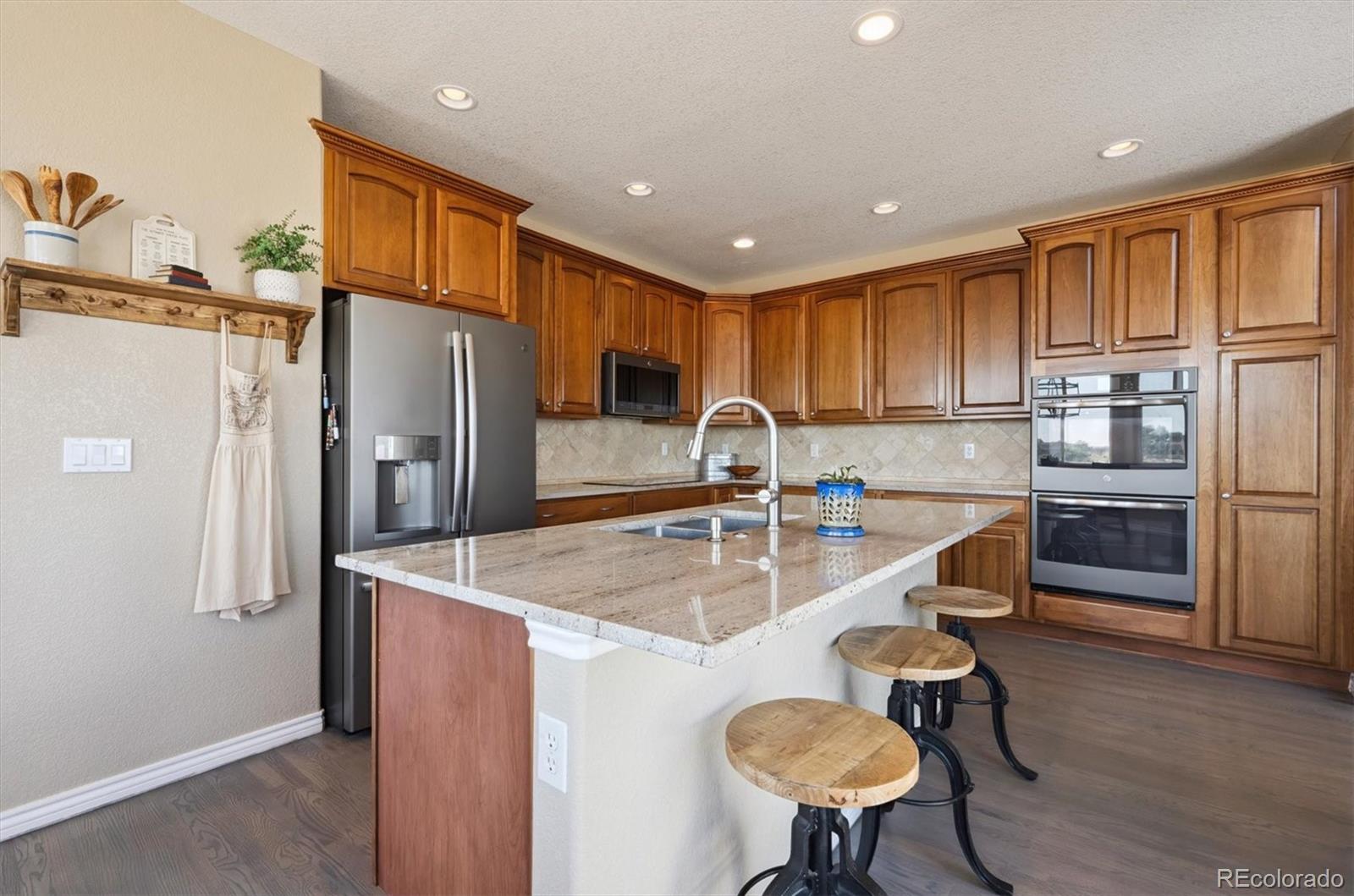 724 Imboden Road Watkins, CO 80137 - Photo 13 of 50 a kitchen with stainless steel appliances granite countertop a refrigerator a sink and a stove