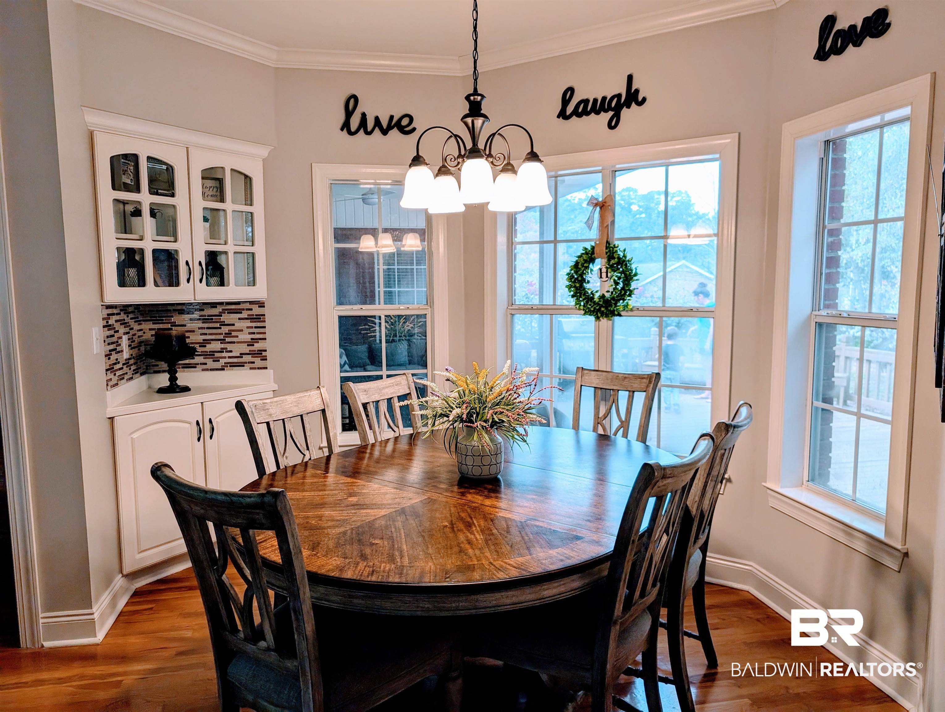 506 Old Castleberry Road Brewton, AL 36426 - Photo 6 of 14 Dining space with an inviting chandelier, dark wood-style flooring, crown molding, and baseboards