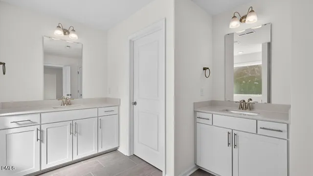 a bathroom with a double vanity sink and mirror with window