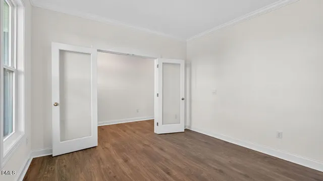 a view of an empty room with wooden floor