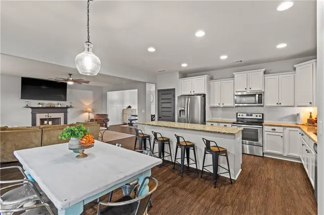 a large kitchen with kitchen island a stove a sink a dining table and chairs
