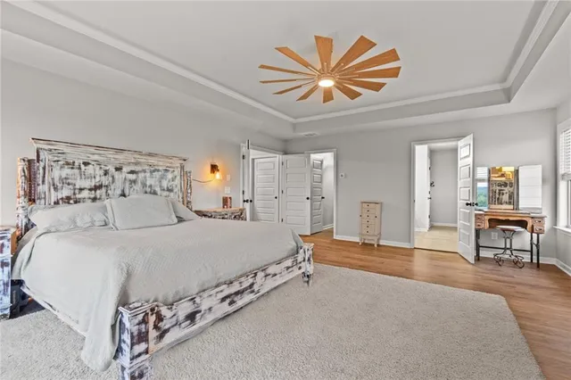 a spacious bedroom with a bed and a chandelier