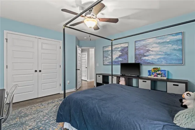 a bedroom with a bed dresser and wooden floor