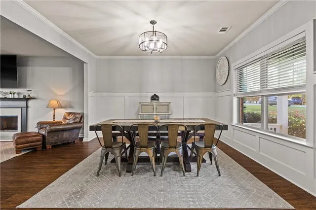a dining room with furniture a chandelier and wooden floor