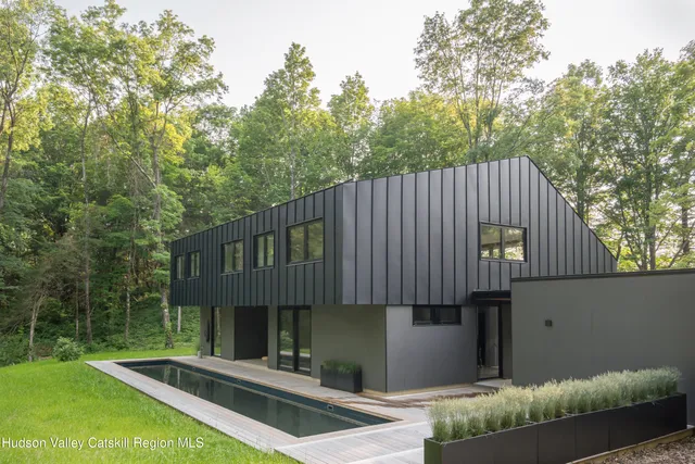 a front view of a house with swimming pool and sitting area