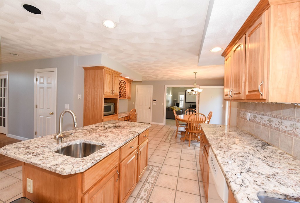 244 Hayden Road Groton, MA 01450 - Photo 4 of 23 a large kitchen with kitchen island a large counter space wooden floor and appliances