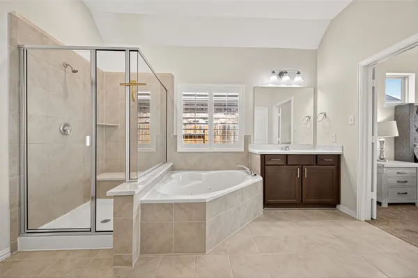 a spacious bedroom with a bed and a chandelier