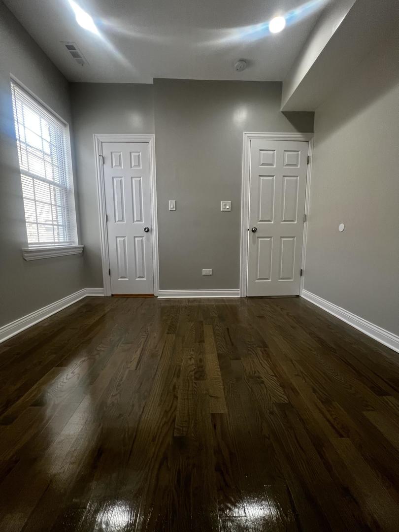 3257 West Warren Boulevard, Unit 2 Chicago, IL 60624 - Photo 13 of 21 an empty room with wooden floor and windows