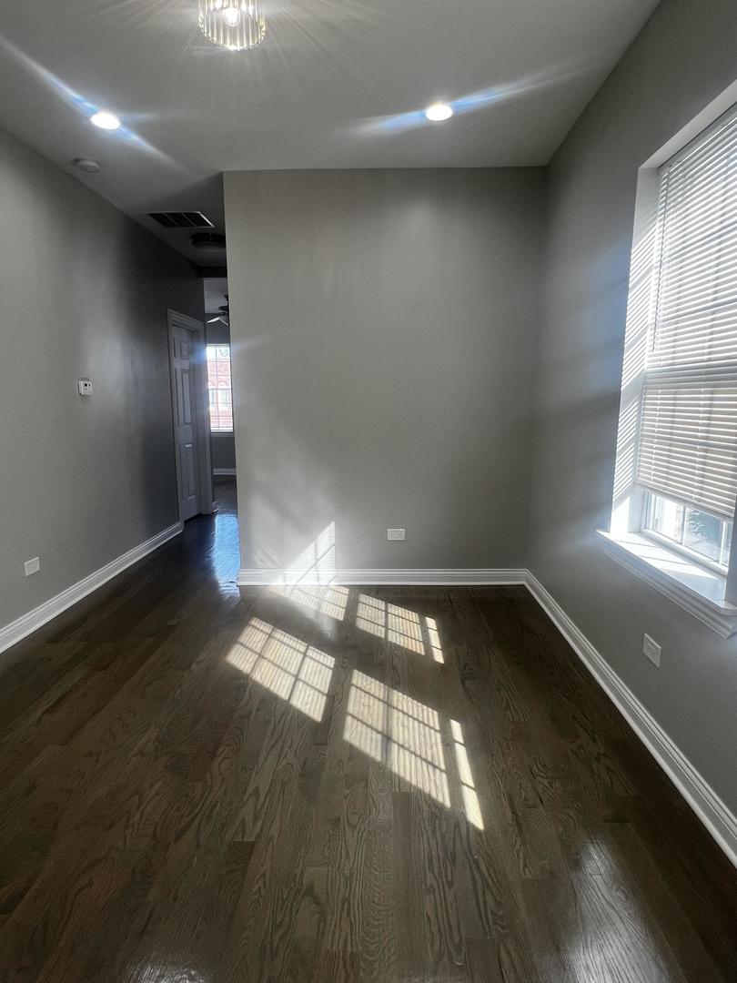 3257 West Warren Boulevard, Unit 2 Chicago, IL 60624 - Photo 16 of 21 an empty room with wooden floor and windows