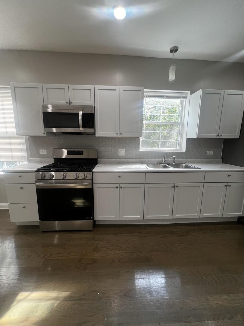 3257 West Warren Boulevard, Unit 2 Chicago, IL 60624 - Photo 17 of 21 a kitchen with granite countertop a sink a stove and cabinets