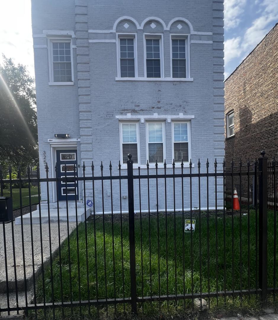 3257 West Warren Boulevard, Unit 2 Chicago, IL 60624 - Photo 2 of 21 a view of a brick house with a small yard